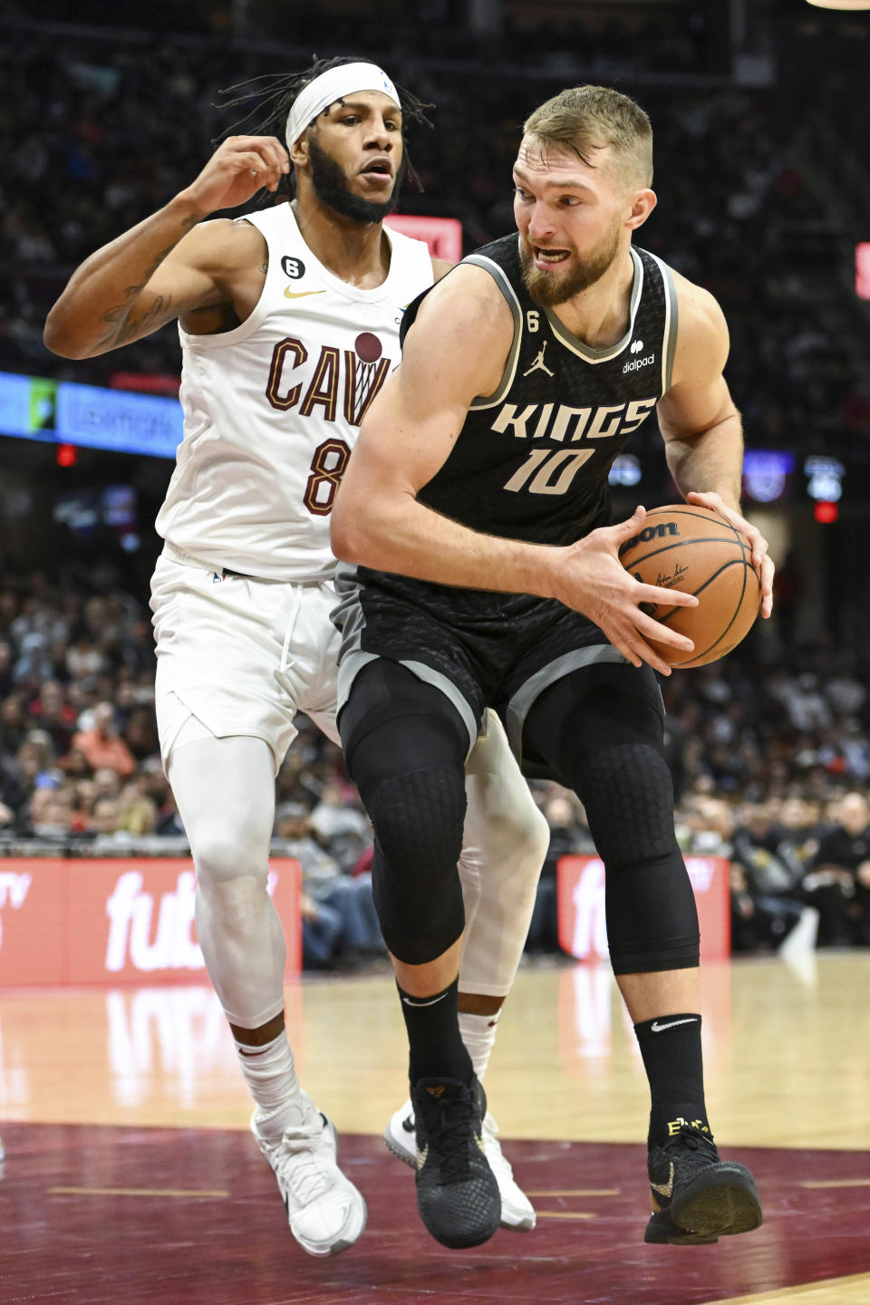 Sacramento Kings forward Domantas Sabonis (10) drives against Cleveland Cavaliers forward Lamar Stevens (8) during the second half of an NBA basketball game, Friday, Dec. 9, 2022, in Cleveland. (AP Photo/Nick Cammett)