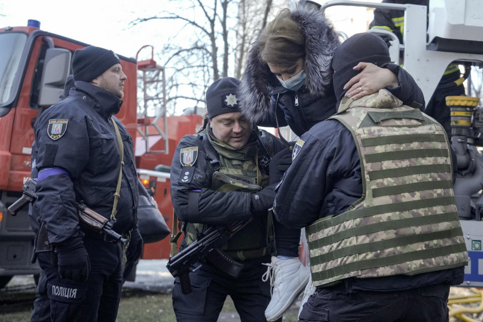 Policemen help a woman who was evacuated by firefighters from a destroyed apartment building after a bombing in a residential area in Kyiv, Ukraine, Tuesday, March 15, 2022. Russia's offensive in Ukraine has edged closer to central Kyiv with a series of strikes hitting a residential neighborhood as the leaders of three European Union member countries planned a visit to Ukraine's embattled capital. (AP Photo/Vadim Ghirda)