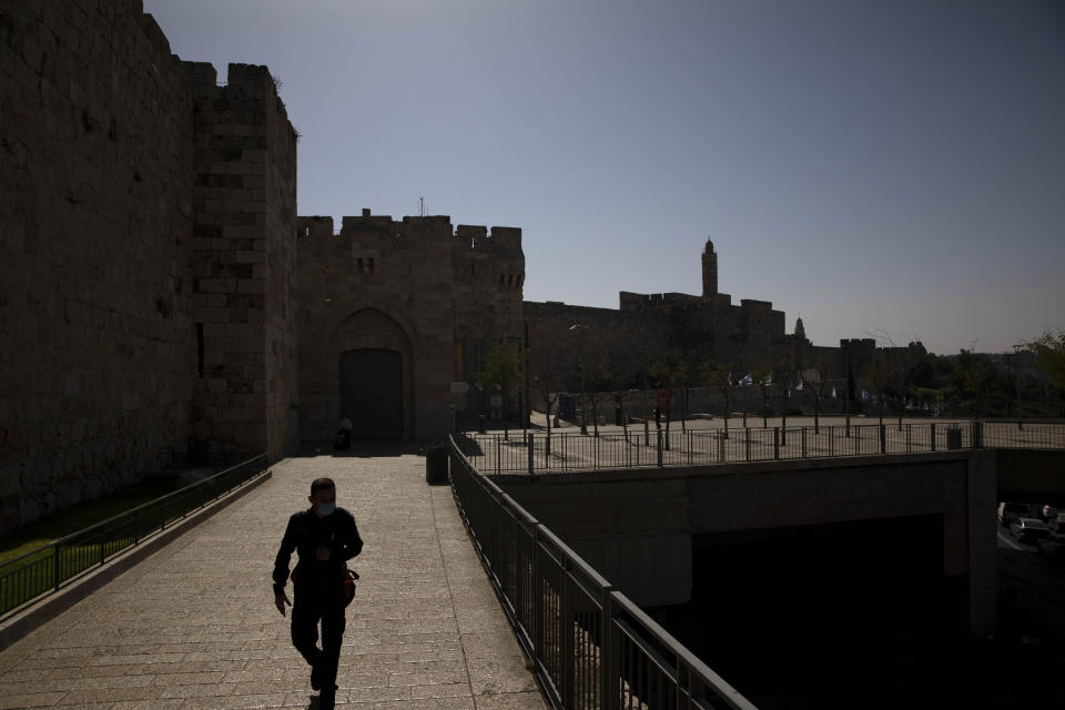 An Israeli police officer walks during the current nationwide lockdown due to the coronavirus pandemic outside the Jaffa Gate in Jerusalem's old city, Tuesday, Sept. 29, 2020. (AP Photo/Sebastian Scheiner)