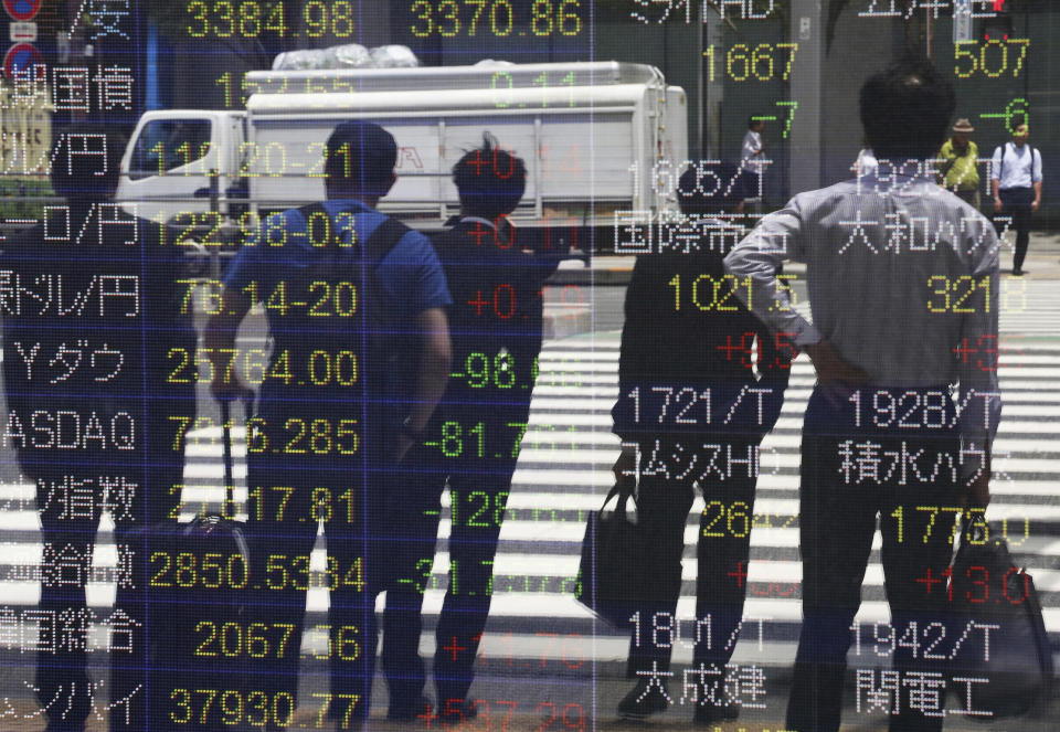 People are reflected on the electronic board of a securities firm in Tokyo, Monday, May 20, 2019. Shares are mixed in Asia, with India and Australia leading gains following elections that look set to keep incumbents in office. (AP Photo/Koji Sasahara)