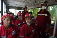 Members of the Cuban Red Cross wait to be transported to the Matanzas Supertanker Base, where firefighters work to quell a blaze which began during a thunderstorm the night before, in Matazanas, Cuba, Saturday, Aug. 6, 2022. The fire at an oil storage facility raged uncontrolled Saturday, where four explosions and flames injured nearly 80 people and left over a dozen firefighters missing, Cuban authorities said. (AP Photo/Ramon Espinosa)