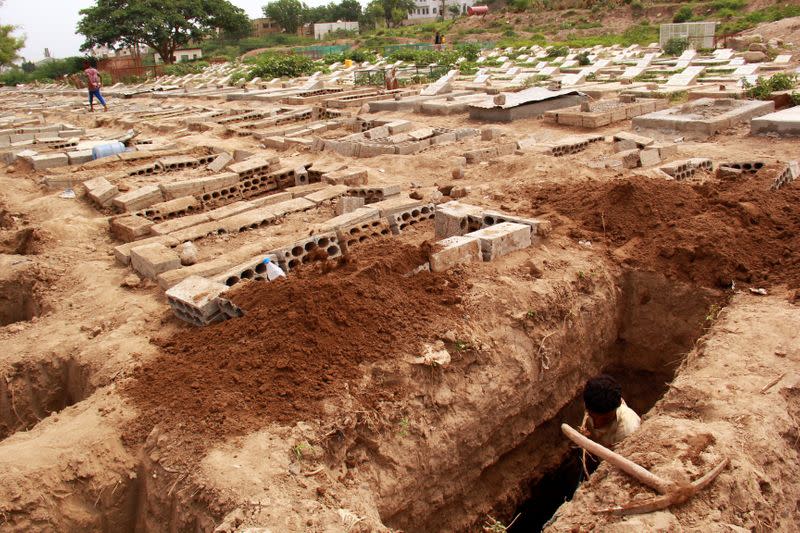 FILE PHOTO: A man digs a grave at a cemetery where victims of the coronavirus disease (COVID-19) are buried in Taiz