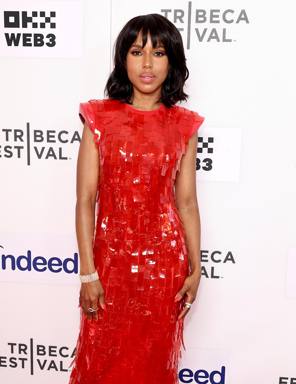 Kerry Washington poses on the red carpet at the Tribeca Festival. She is wearing a sleeveless, textured red dress