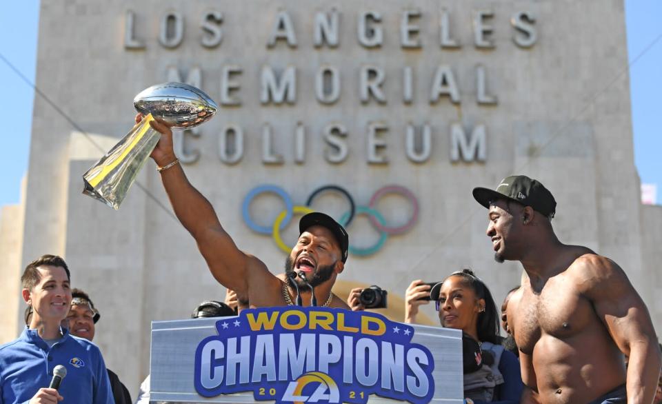 Rams defensive end Aaron Donald holds up the Lombardi Trophy at as rally outside the Coliseum.