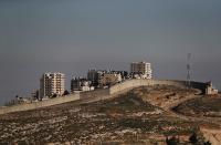 Buildings in the Palestinian town of al-Eizariya are seen beyond the Israeli barrier in the Israeli-occupied West Bank