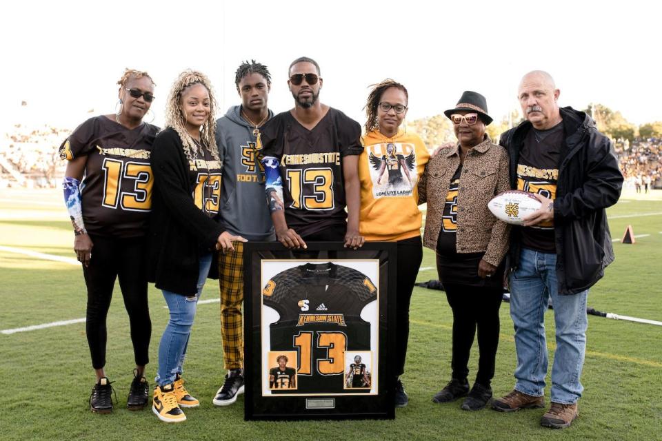 Ladarius Clardy’s family members were presented with a framed jersey by Kennesaw State University at the KSU homecoming football game, and KSU presented the lead detective who investigated Clardy’s murder with a signed football.

The individuals pictures in the photograph are as follows, from left to right: Barbara Reed (Ladarius’ grandmother), Shakema Clardy (his stepmother), Ladarian Clardy (Ladarius’ brother), Ladaron Clardy (Ladarius’ father), Tracey Marshall (his mother), Elizabeth Marshall (his grandmother) and Escambia County Sheriff’s Office Investigator Bruce Harris.