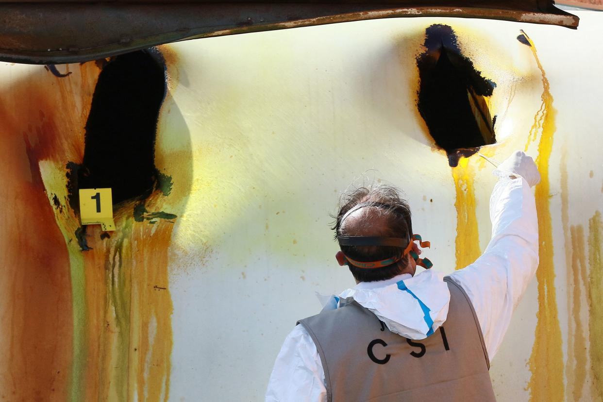 A Jordanian forensics expert inspects the site of a toxic gas explosion in the Red Sea port of Aqaba on June 28, 2022.