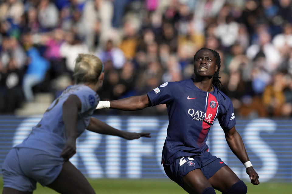 PSG's Tabitha Chawinga eyes the ball while Lyon's Ellie Carpenter, left, runs at her during the women's Champions League semifinal, second leg, soccer match between Paris Saint-Germain and Olympique Lyonnais at Parc des Princes, in Paris, Sunday, April 28, 2024. (AP Photo/Thibault Camus)