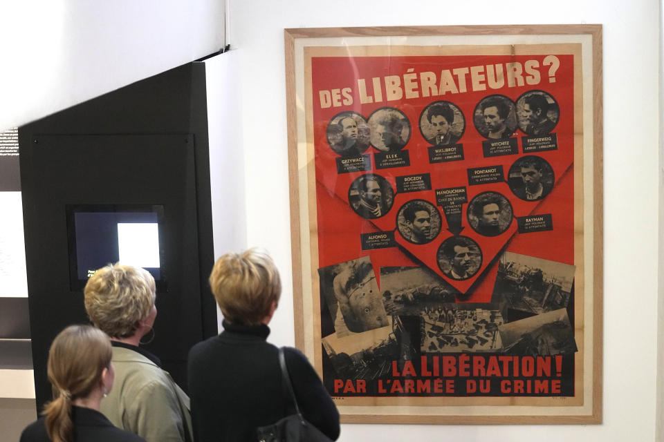 Visitors watch the nazi propaganda poster of Missak Manouchian and his Resistance network, exhibited at the Shoah memorial, Tuesday, Feb. 20, 2024 in Paris. Missak Manouchian will enter into the Pantheon national monument Wednesday during a ceremony presided by French President Emmanuel Macron. Manouchian, who took refuge in France after surviving the Armenian genocide, was executed in 1944 for fighting fascism and leading resistance to Nazi occupation. The Pantheon is the final resting place of France's most revered figures. (AP Photo/Michel Euler)