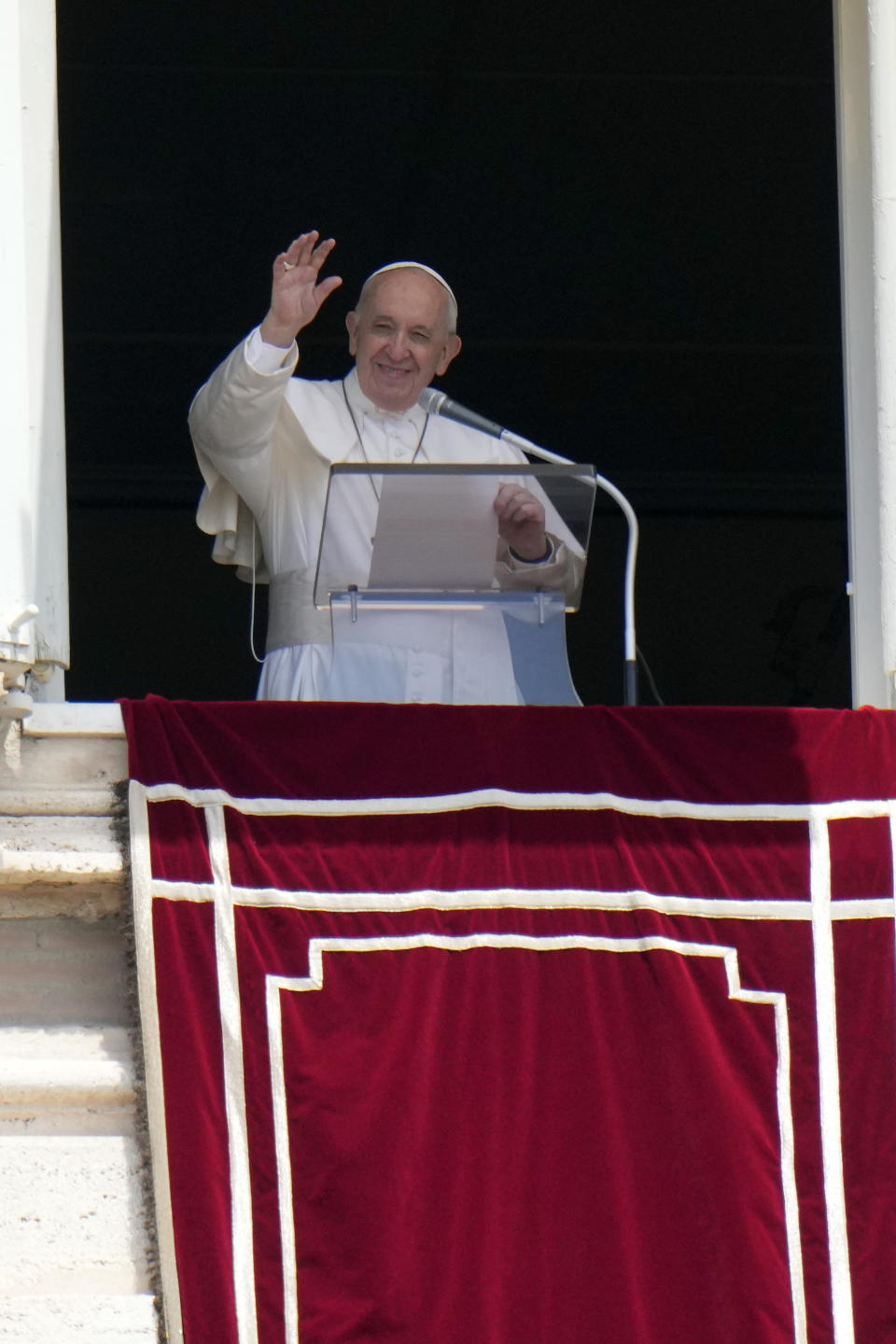Pope Francis waves to faithful during the Angelus noon prayer from the window of his studio overlooking St.Peter's Square, at the Vatican, Sunday, July 4, 2021. In a brief announcement Sunday afternoon the Vatican said Pope Francis has gone to a Rome hospital for scheduled surgery for a stenosis, or restriction, of the large intestine. (AP Photo/Alessandra Tarantino)