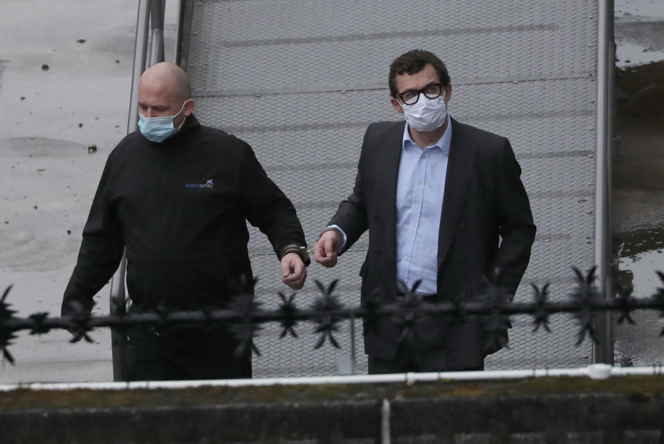 The Earl of Strathmore is escorted in handcuffs from Dundee Sheriff Court. (PA)