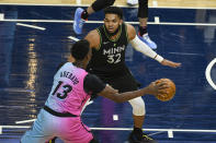 Miami Heat center Bam Adebayo (13) tries to get past Minnesota Timberwolves center Karl-Anthony Towns (32) during the first half of an NBA basketball game Friday, April 16, 2021, in Minneapolis. (AP Photo/Craig Lassig)