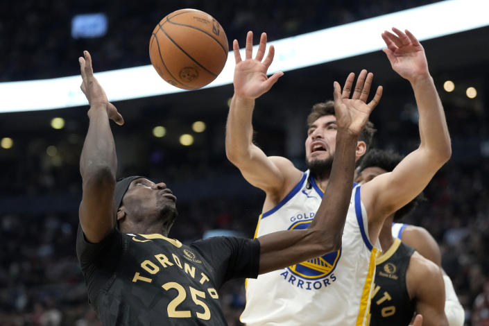 Golden State Warriors guard Ty Jerome, front right, tries to swat the ball away from Toronto Raptors forward Chris Boucher (25) during first-half NBA basketball game action in Toronto, Sunday, Dec. 18, 2022. (Frank Gunn/The Canadian Press via AP)