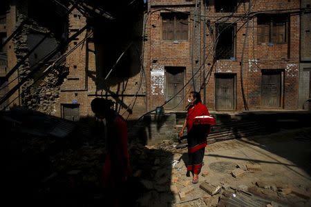 A woman walks along the street near the collapsed house after last week's earthquake in Bhaktapur, Nepal May 2, 2015. REUTERS/Navesh Chitrakar