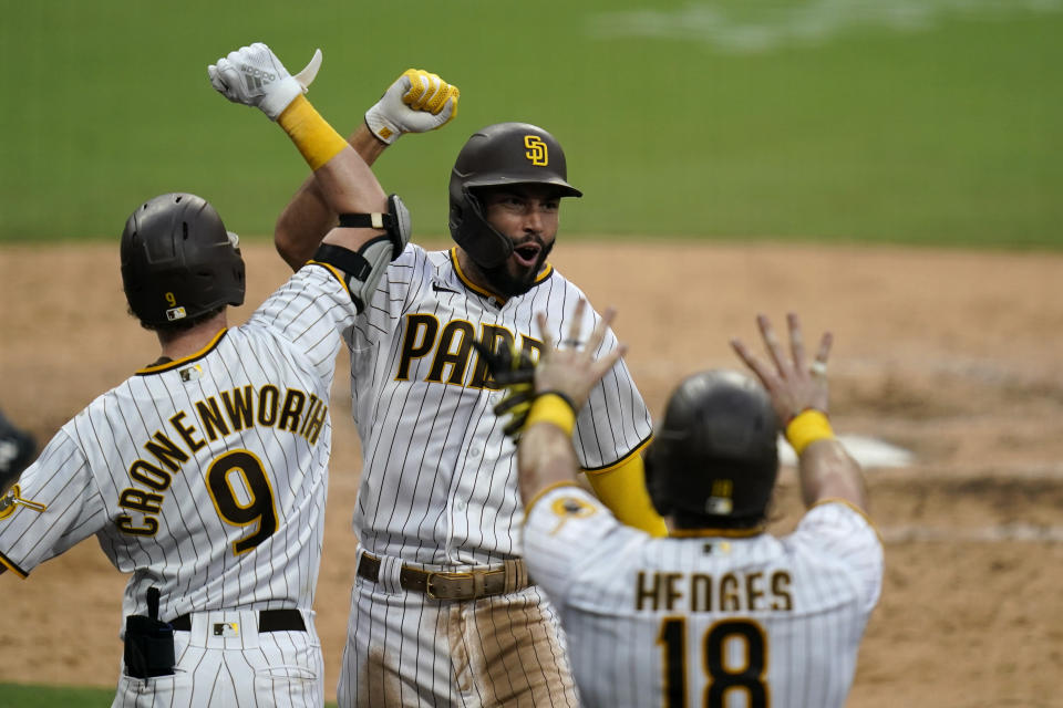 San Diego Padres' Eric Hosmer, facing camera, reacts with teammates after hitting a grand slam during the fifth inning of a baseball game against the Texas Rangers, Thursday, Aug. 20, 2020, in San Diego. (AP Photo/Gregory Bull)