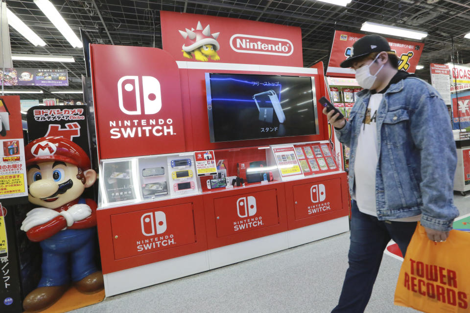 A man walks an advertisement of Nintendo Switch at an electronics retail chain store in Tokyo on Oct. 13, 2021. (AP Photo/Koji Sasahara)