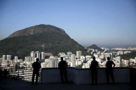 Police officers stand overlooking the city, at Santa Marta slum in Rio de Janeiro, Brazil, June 18, 2015. REUTERS/Pilar Olivares