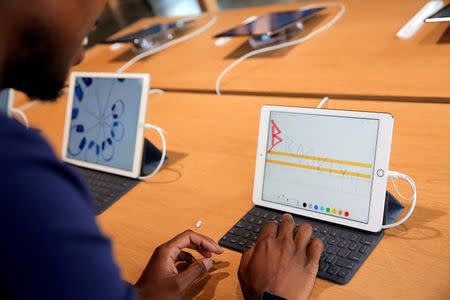 A store employee uses an iPad during a preview event at the new Apple Store Williamsburg in Brooklyn, New York, U.S., July 28, 2016. REUTERS/Andrew Kelly