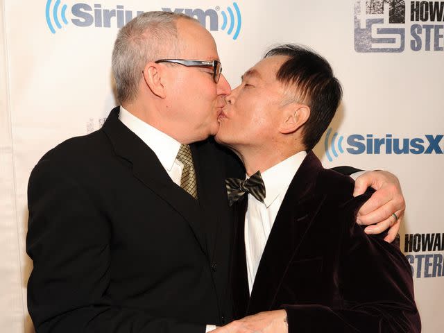 <p>Kevin Mazur/Getty </p> Brad Takei (left) and George Takei