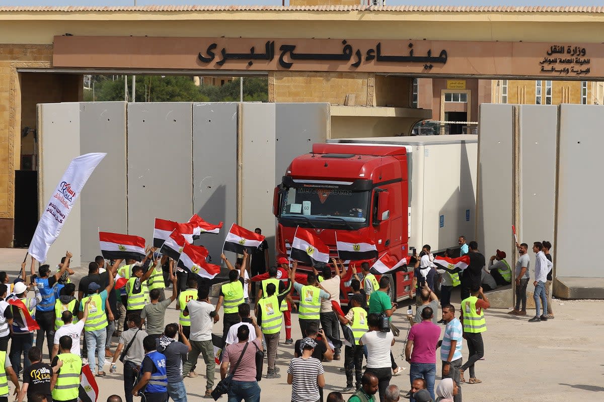 Egyptian aid workers watch as a truck crosses back into Egypt through the Rafah border crossing with Gaza on 21 October, 2023 (AFP via Getty Images)