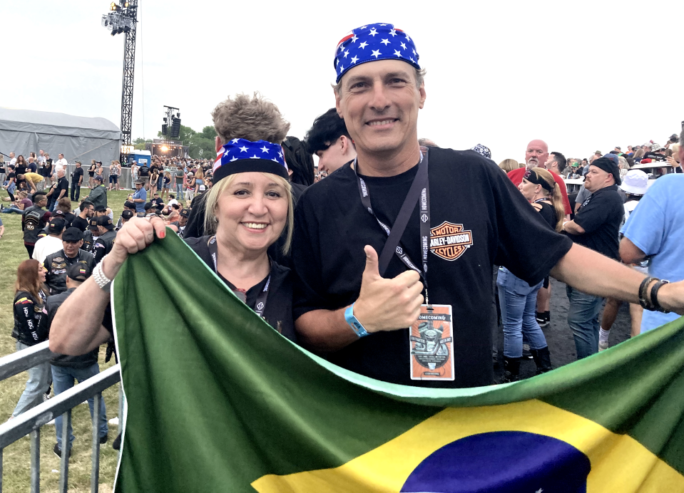 Neusa and Joäo Carlos from Brazil celebrating at Veterans Park for the Harley-Davidson 120 anniversary showing the Brazil flag and American accessories.