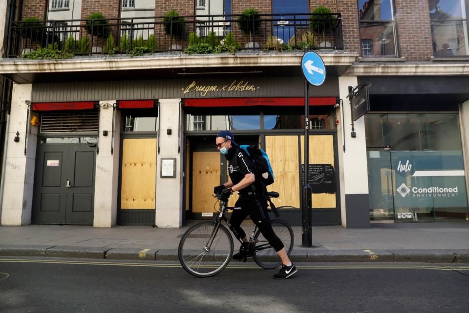 medical courier Ben Gee, who works for The Doctors Laboratory, cycles away after picking up a coronavirus test sample in London: AP