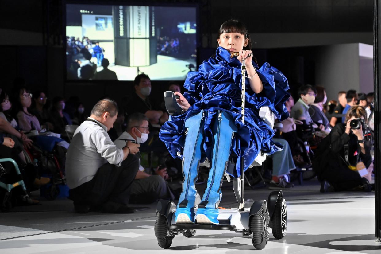 Ein Model in einem elektrischen Rollstuhl auf der NextUd Japan 2023 (Bild: Kazuhiro NOGI / AFP)