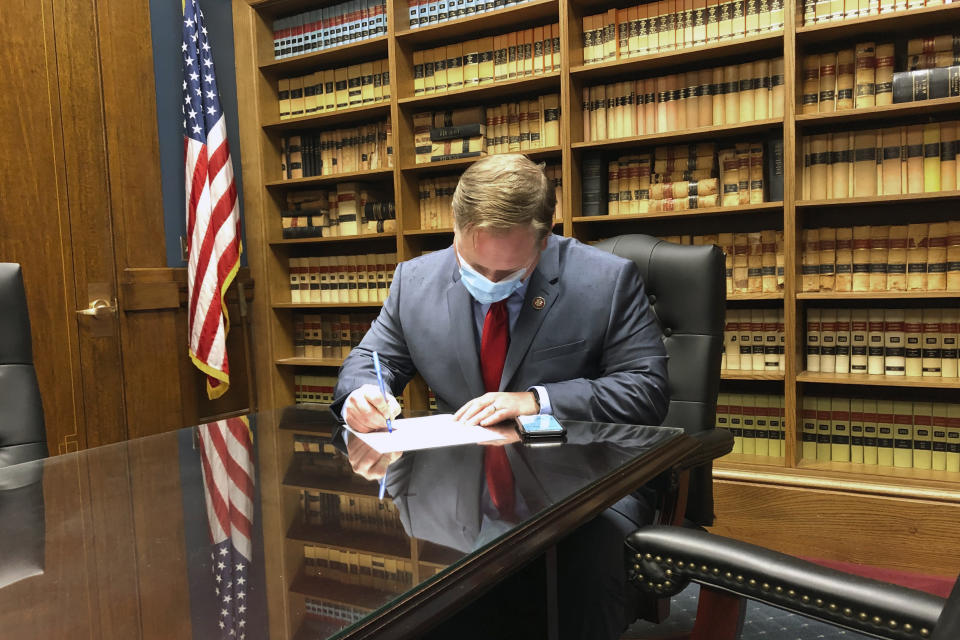 In this Tuesday, May 26, 2020 photo, U.S. Rep. Steve Watkins, R-Kan., fills out the necessary paperwork at the Kansas secretary of state's office in Topeka, Kan., to get his name on the ballot for re-election. Watkins is facing a tough primary challenge from State Treasurer Jake LaTurner. (AP Photo/John Hanna)