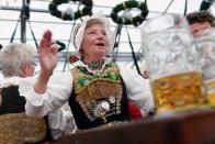 A woman from Lower Bavaria, dressed in ceremonial Bavarian costume, enjoys a beer after participating in the opening parade. The 16-day festival runs till October 7.