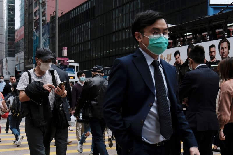 FILE PHOTO: People wear protective face masks as they take their lunch breaks at the financial Central district, following the outbreak of the novel coronavirus, in Hong Kong