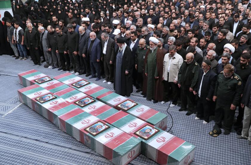 Prayer over the flag-draped coffins of the Revolutionary Guards members who were killed in an airstrike in Syria.