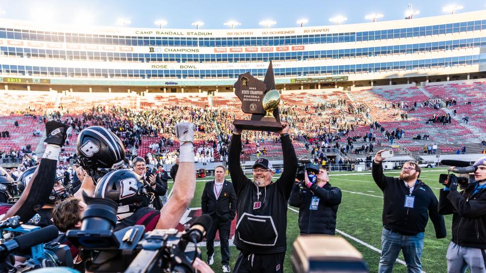 Badger head coach Matt Hensler hoists the championship trophy after a 34-33 victory over Waunakee in the WIAA Division 2 state championship football game at Camp Randall Stadium in Madison on Friday, November 17, 2023.