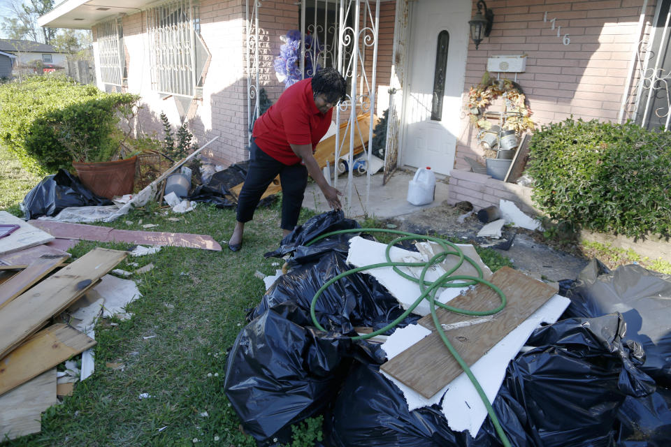 Lydia Larce goes through construction debris at her home in Lake Charles, La., on Thursday, March 31, 2022. More than a year after Hurricane Laura wreaked havoc on area, Larce is living in a FEMA trailer behind her home. She fears that emissions from the oil and gas industry — including the growing number of liquid natural gas export facilities along the Gulf Coast — will worsen global warming. "Our politicians in D.C., they're not taking it seriously," she says. (AP Photo/Martha Irvine)