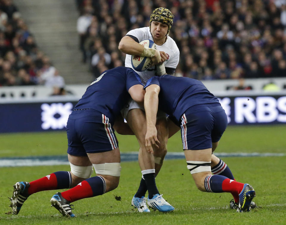 England's Jack Nowell, center, is tackled by France's Louis Picamoles, left, and Alexandre Flanquart during their Six Nations international rugby union match between France and England at Stade de France stadium in Saint Denis, near Paris, Saturday, Feb. 1, 2014. (AP Photo/Michel Euler)