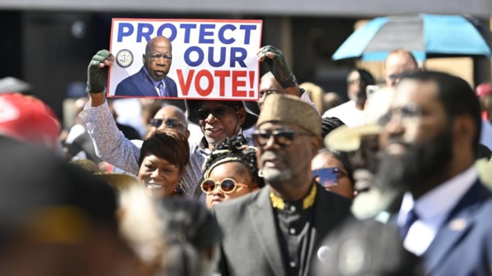 People gathered in Selma, Alabama, on Sunday to listen to the speech of President Joe Biden on the 58th anniversary of Bloody Sunday at the Edmund Pettus Bridge. One sign bears the likeness of the late Rep. John Lewis, who was among the marchers beaten in 1965. (Photo: Peter Zay/Anadolu Agency via Getty Images)