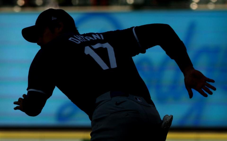 Dodgers star Shohei Ohtani warms up before a spring training game against the Angels at Angels Stadium Tuesday.