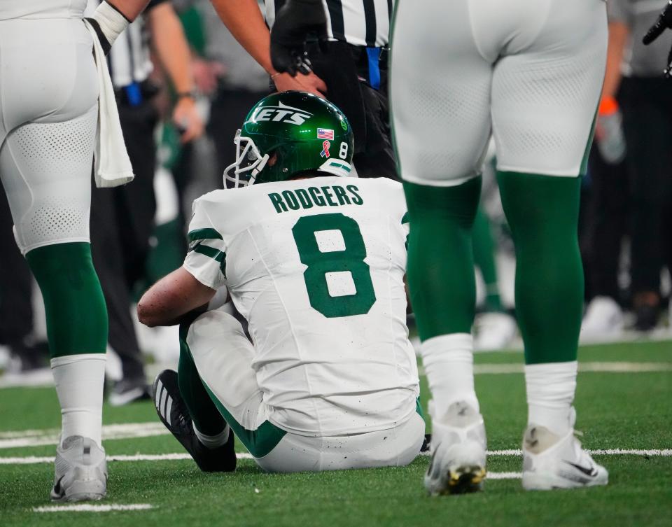 New York Jets quarterback Aaron Rodgers (8) sits on the field after a sack by Buffalo Bills defensive end Leonard Floyd (not pictured) at MetLife Stadium. Rodgers left the game with an injury after the play.