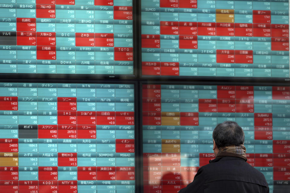 A man looks at an electronic stock board showing Japan's Nikkei 225 index at a securities firm in Tokyo, Friday, Feb. 7, 2020. Asian stock markets have retreated following a surge driven by a Chinese tariff cut on U.S. imports. (AP Photo/Eugene Hoshiko)