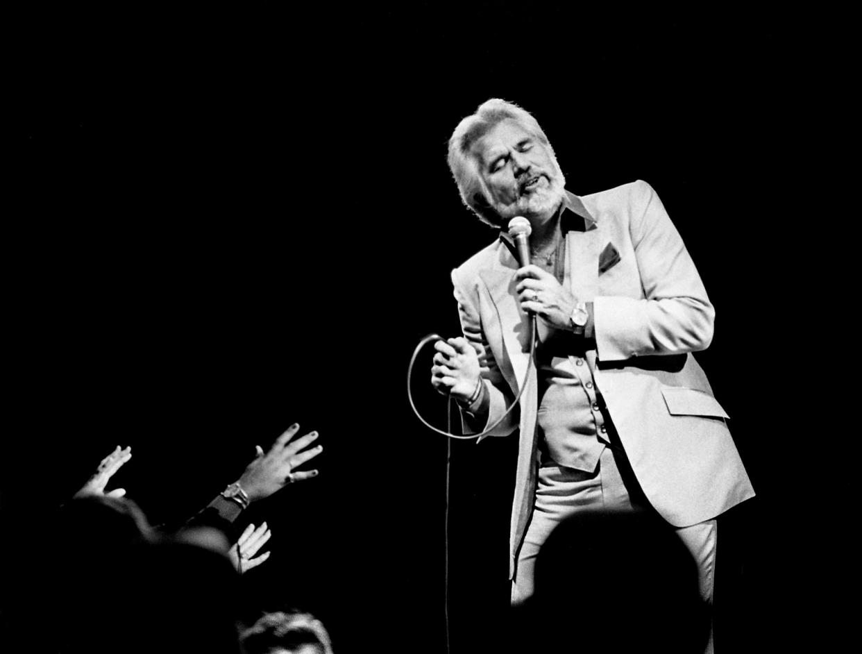 Headliner Kenny Rogers sways in song while his faithful fans reach for his attention during the sold-out concert at the Municipal Auditorium on Nov. 5, 1983. Rogers along with the Righteous Brothers and B.J. Thomas make the concert a true Middle America musical “event.”