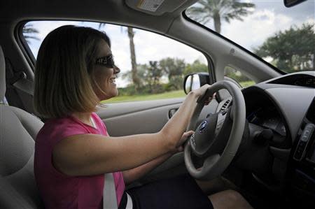 Chrissy Garton, Director of Social Innovation at Rollins College, test drives an electric car as part of the Drive Electric Orlando program at the Peabody Orlando Hotel in Orlando, Florida, September 5, 2013. The initiative is promoting electric car rentals starting with 15 cars available to rent with 26 partner hotels with charging stations while area theme parks have committed to building charging stations. REUTERS/David Manning