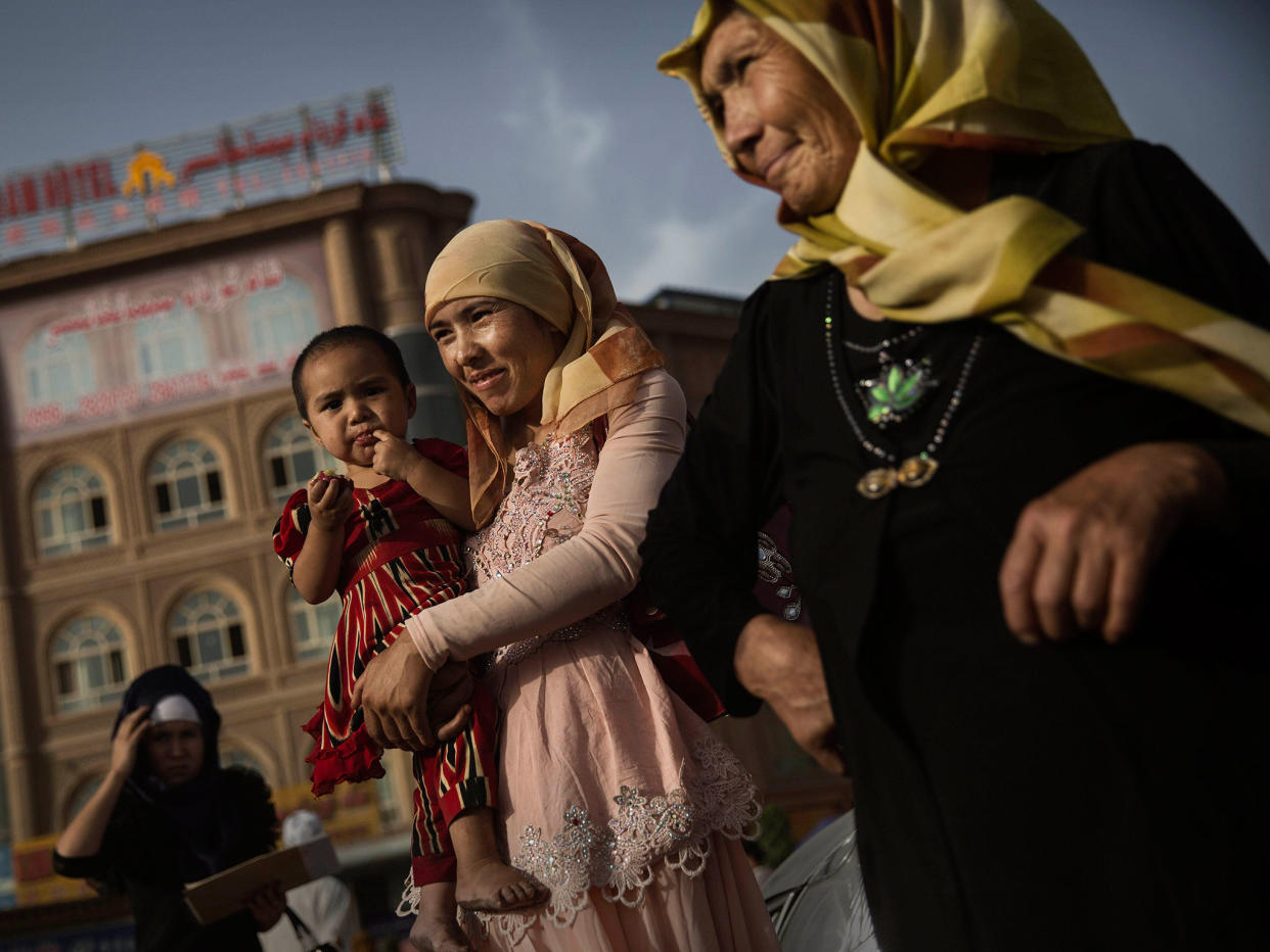 A Uighur woman walks with her baby at a market on August 1, 2014 in old Kashgar, Xinjiang Province, China: Getty