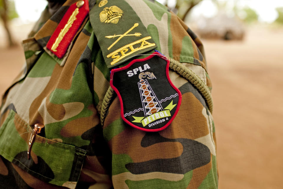 A Sudan People's Liberation Army (SPLA) commander dons the new insignia of the 4th Division petroleum defense unit in Bentiu, Unity State, South Sudan on Friday, May 11, 2012. In late April, tensions between Sudan and South Sudan erupted into armed conflict along their poorly defined border. Thousands of SPLA forces have been deployed to Unity State where the two armies are at a tense stalemate around the state's expansive oil fields. Fighting between the armies lulled in early May after the U.N. Security Council ordered the countries to resume negotiations. South Sudan seceded from the Republic of Sudan in July 2011 following decades of civil war. (AP Photo/Pete Muller)