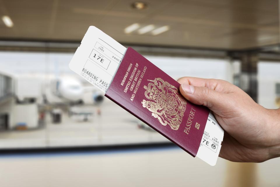 person handing over passport and plane ticket 