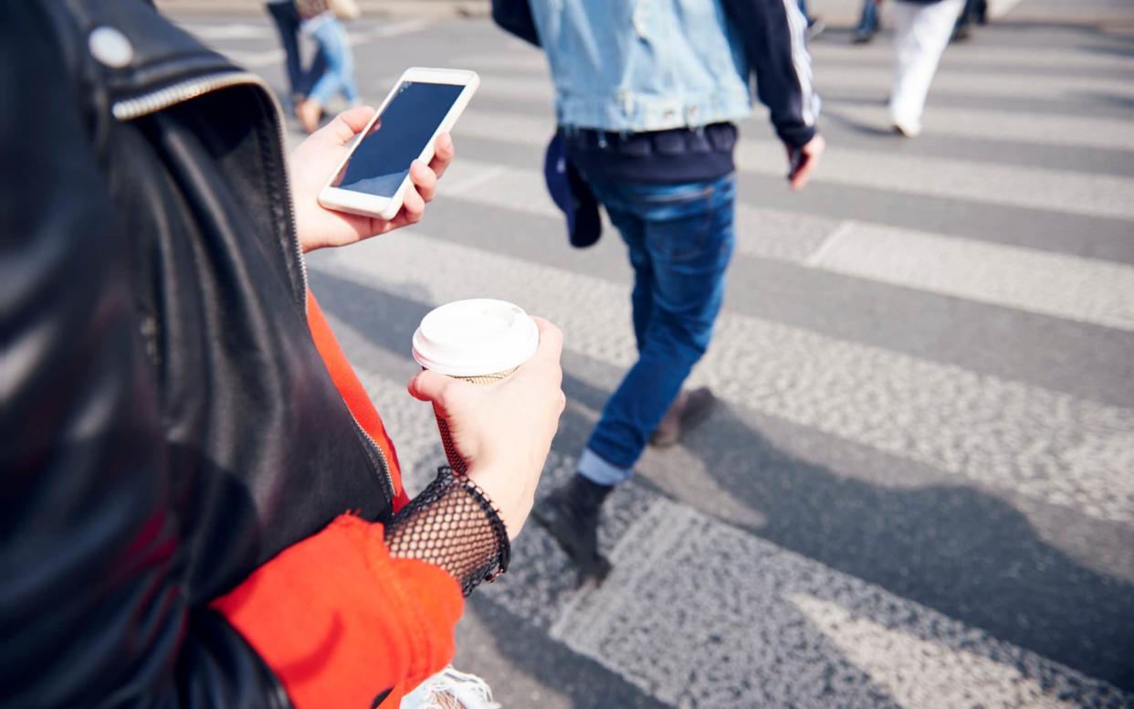 A recent case has highlighted the potential danger of crossing a road while looking at your phone - Cultura RF