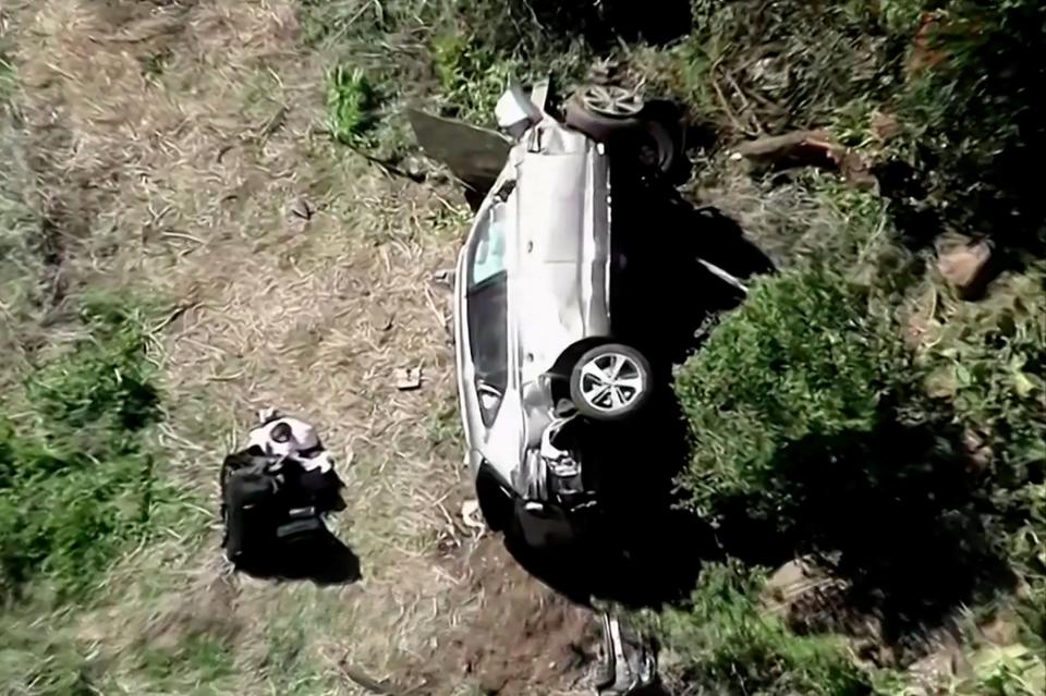 The vehicle of golfer Tiger Woods, who was rushed to hospital after suffering multiple injuries, lies on its side after being involved in a accident (via REUTERS)