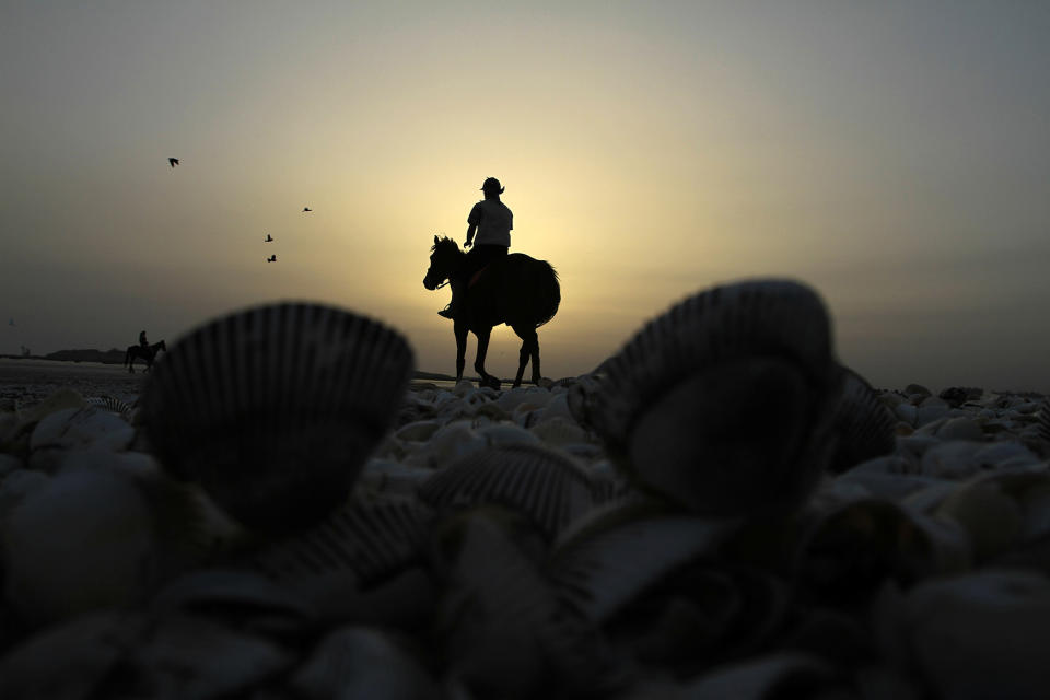 <p>A man rides a horse at Karachi’s beach area in Pakistan on Feb 27, 2012. (AP Photo/Shakil adil) </p>