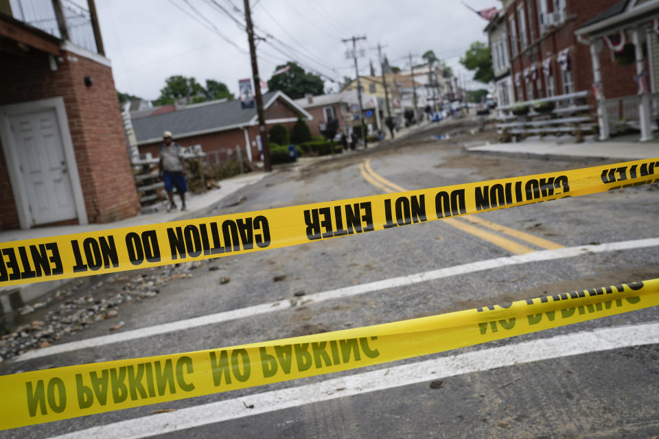 Police tape crosses Main Street after floodwaters damaged the roadway and adjacent buildings the previous day, Monday, July 10, 2023, in Highland Falls, N.Y. Heavy rain has washed out roads and forced evacuations in the Northeast as more downpours were forecast throughout the day. One person in New York's Hudson Valley has drowned as she was trying to leave her home. (AP Photo/John Minchillo)