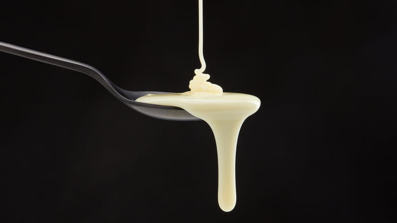 Condensed milk dripping off spoon