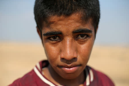 Palestinian songbird catcher Hamza Abu Shalhoub, 16, poses for a photo at the site of Gaza destroyed airport, in Rafah in the southern Gaza Strip November 8, 2018. Picture taken November 8, 2018. REUTERS/Ibraheem Abu Mustafa