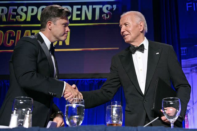<p>BRENDAN SMIALOWSKI/AFP via Getty</p> Joe Biden greets Colin Jost at the 2024 White House Correspondents' Association (WHCA) dinner